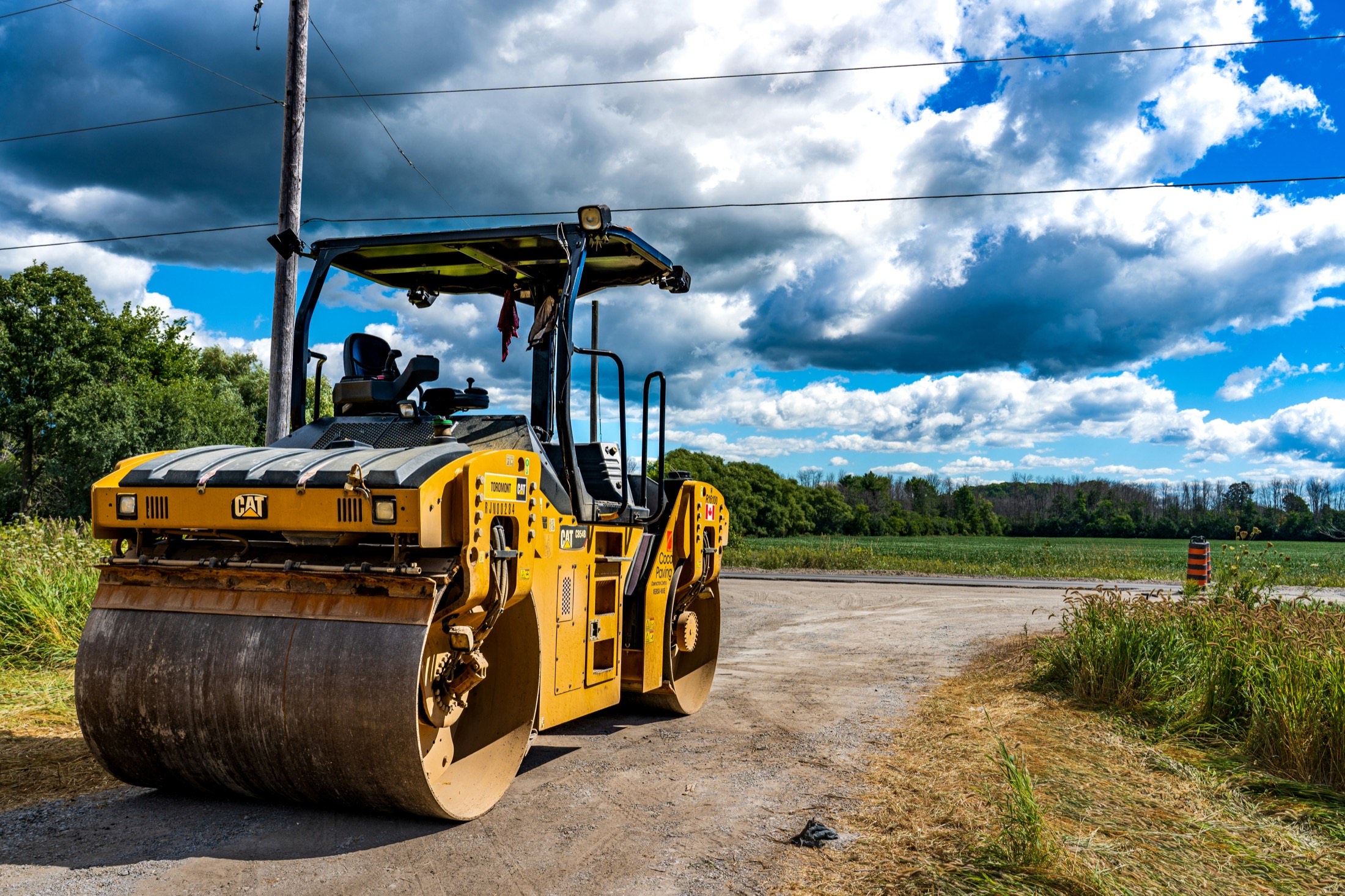 A road roller compacting fresh asphalt during a street resurfacing project.